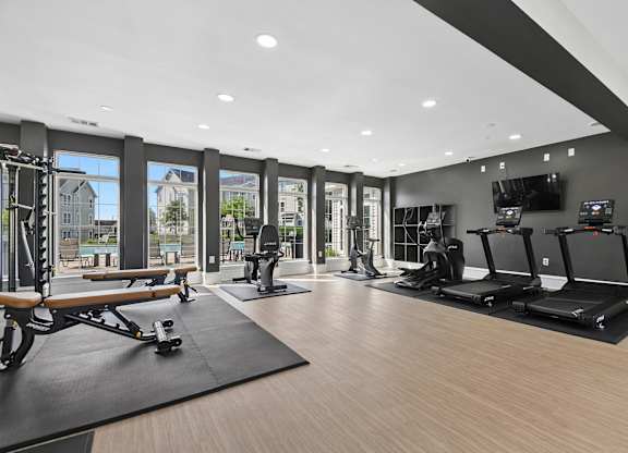 A gym with treadmills, elliptical machines, and a rowing machine.