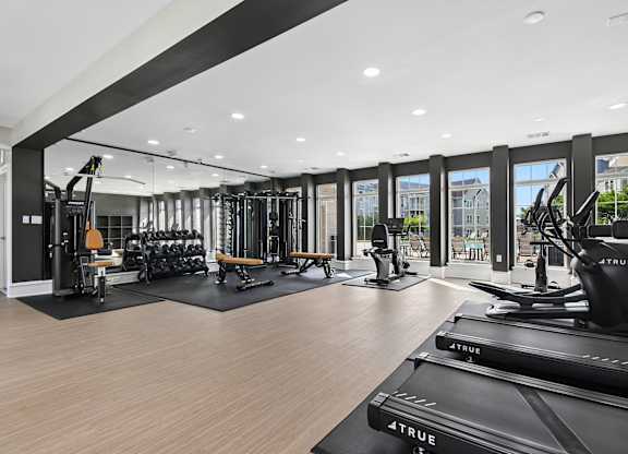 A gym with treadmills, weights, and exercise equipment.