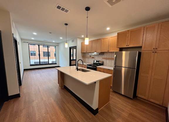 Kitchen with brown cabinets at The Yard Apartments, Kentucky, 40202
