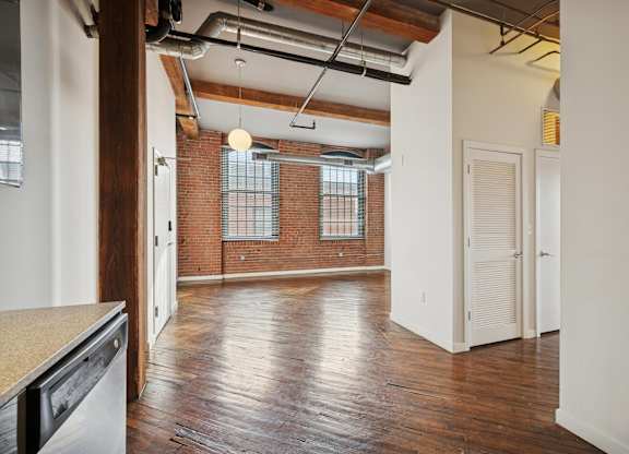 A room with wooden floors and a brick wall.