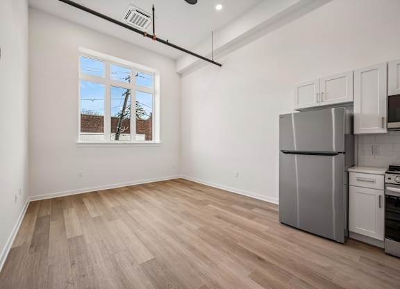 A kitchen area with a refrigerator, oven, and microwave.