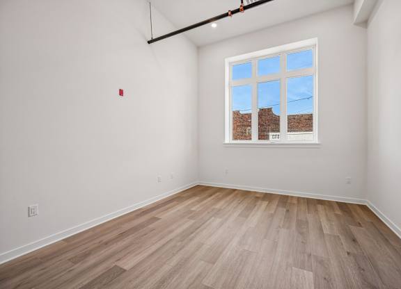 A room with a window showing a brick wall outside.
