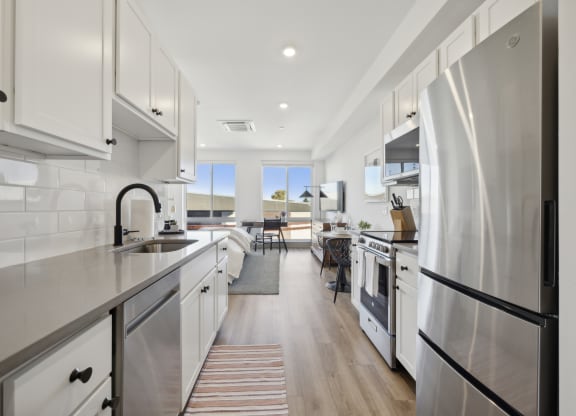 a large kitchen with stainless steel appliances and white cabinets at The Commons On Ludlow Apartments, Philadelphia