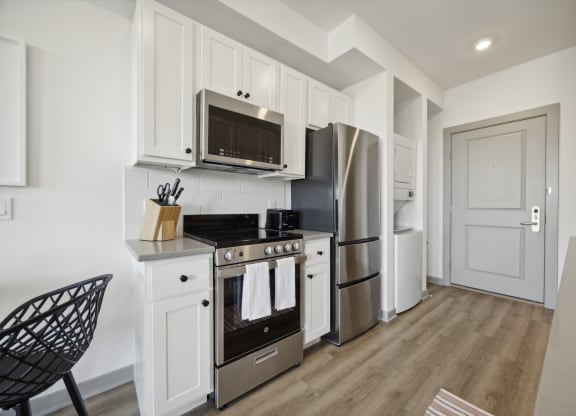 a kitchen with white cabinets and stainless steel appliances at The Commons On Ludlow Apartments, Pennsylvania