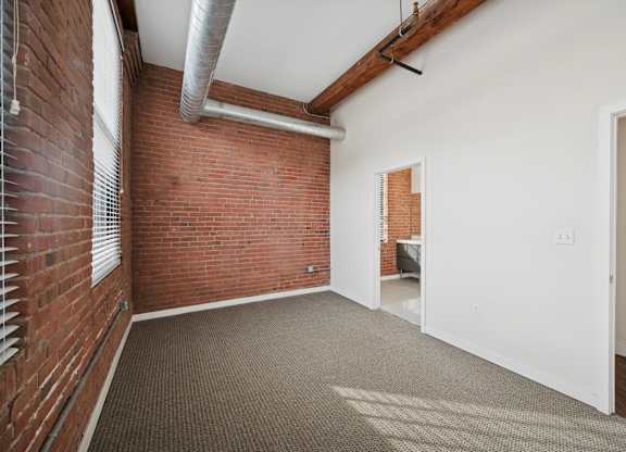 A room with a brick wall and a carpeted floor.