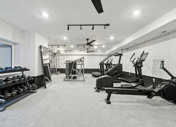 A spacious gym with a variety of equipment including treadmills, weights, and exercise machines.