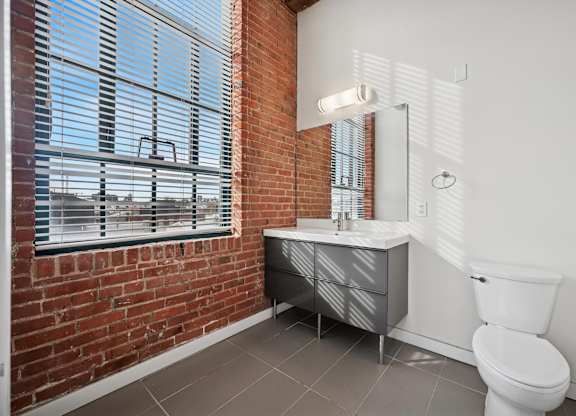 A bathroom with a white toilet and a mirror above a sink.