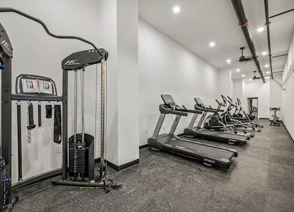 A gym with treadmills, elliptical machines, and other exercise equipment.