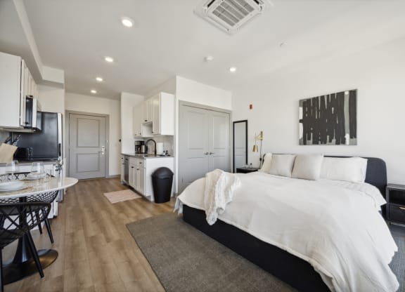 a bedroom with a large bed and a kitchen with a sink at The Commons On Ludlow Apartments, Philadelphia, 19104