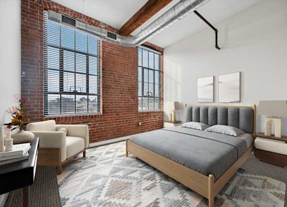 A bedroom with a large bed and a chair by the window.