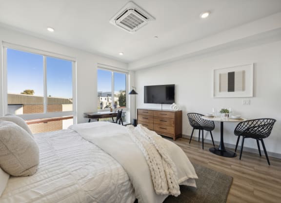 a bedroom with a bed and a desk and a tv at The Commons On Ludlow Apartments, Philadelphia, Pennsylvania