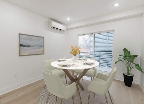 A dining room with a white table and chairs.