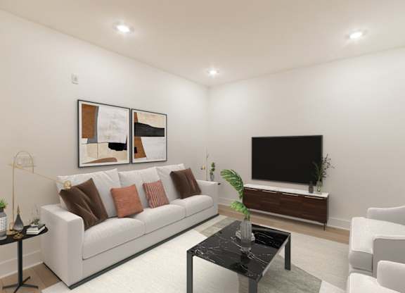 A living room with a white couch, a black coffee table, and a flat screen TV.