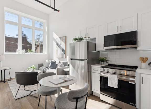 A modern kitchen with a dining table and chairs.