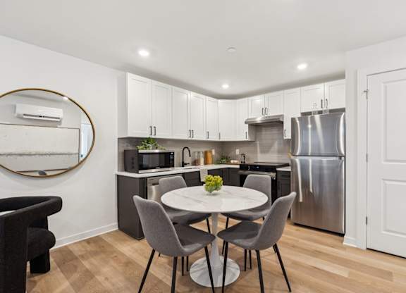 A modern kitchen with a table at The Isaac Apartments, Philadelphia, PA