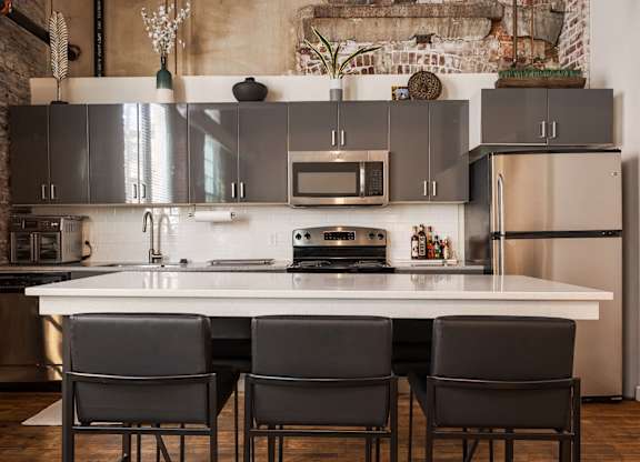 A kitchen with a white table and black chairs.
