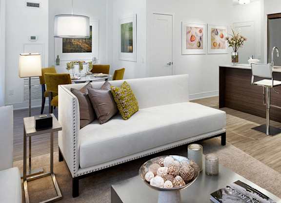 A modern living room with a white sofa and a coffee table.