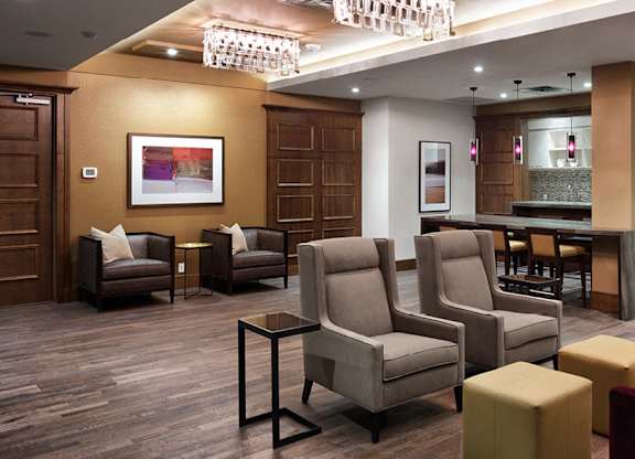 A party room with brown chairs and a red couch.