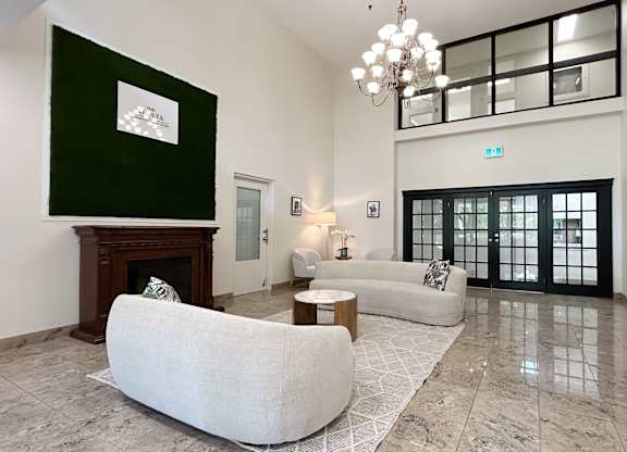 A living room with a white sofa and a fireplace.