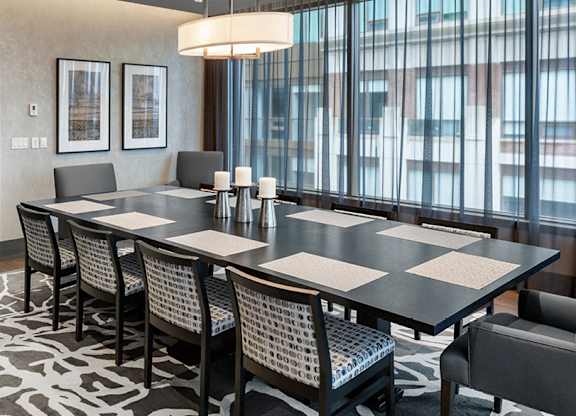 A dining room with a large table and chairs.