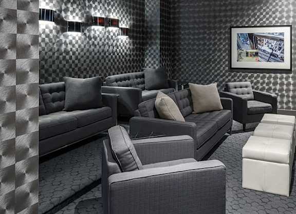 A theatre room with grey furniture and a painting on the wall.