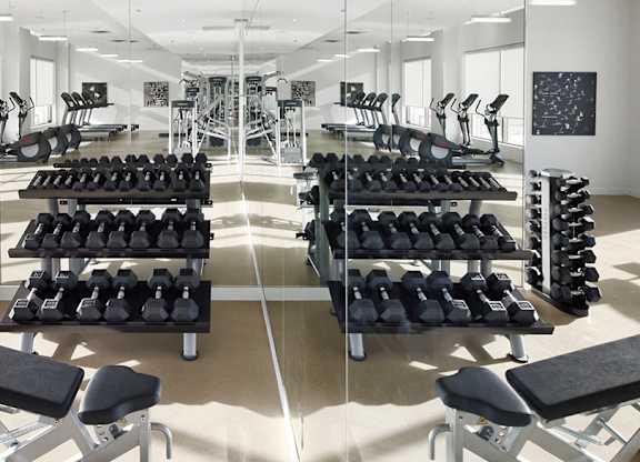 A gym with a variety of equipment including weights and benches.