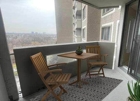 a small balcony with a table and chairs on it