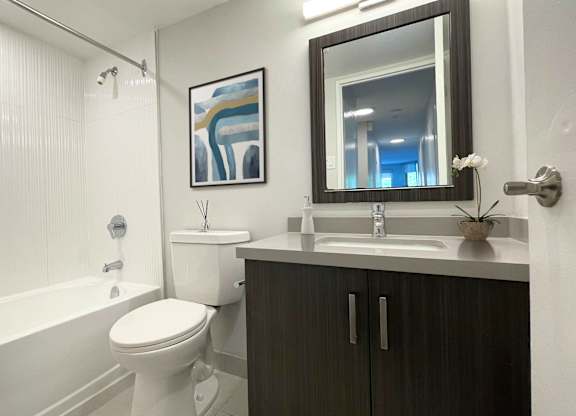 A bathroom with a white toilet, a white sink, and a white shower curtain.