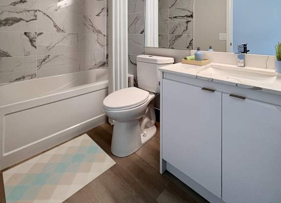 A white toilet sits in a bathroom with marble tiles.