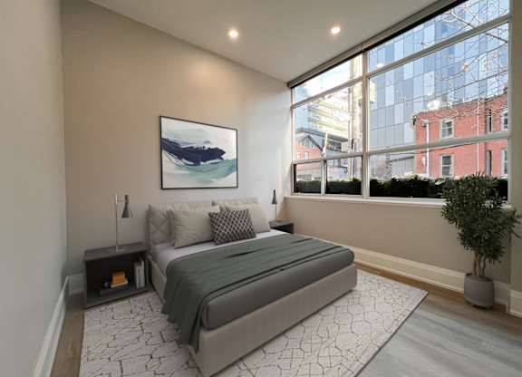 A bedroom with a large bed and a painting on the wall.