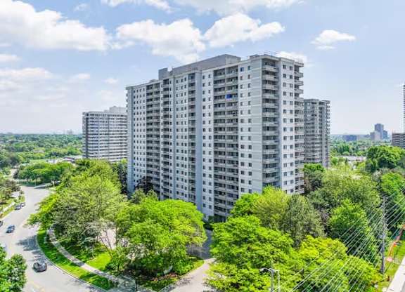 A large building with a lot of windows is surrounded by trees.