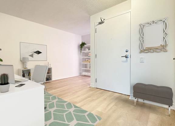 a living room with a white desk and a white door