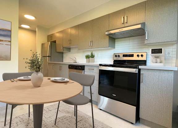 A modern kitchen with a round table and chairs.