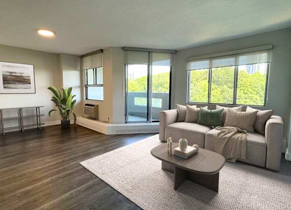 A living room with a couch, a coffee table, and a plant.