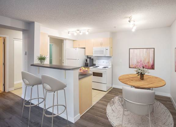 A kitchen with a bar area and a dining table.