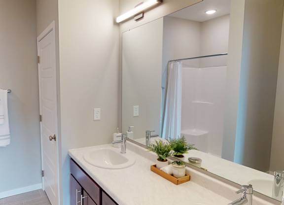 A bathroom with a white sink and a mirror.