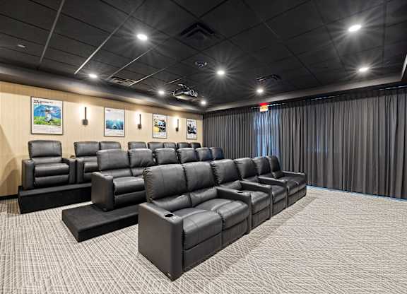 A row of black leather seats in a movie theater.
