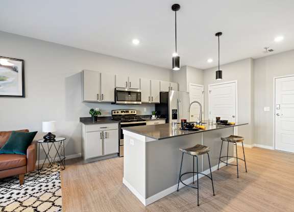 A modern kitchen with a bar stool and a chair.