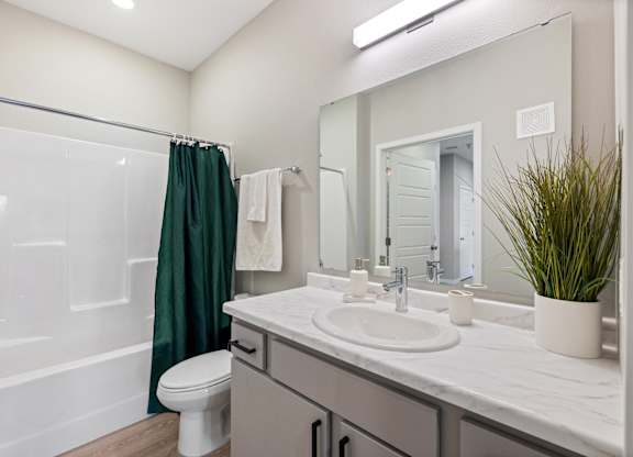 A bathroom with a white toilet, a white sink, and a white bathtub.