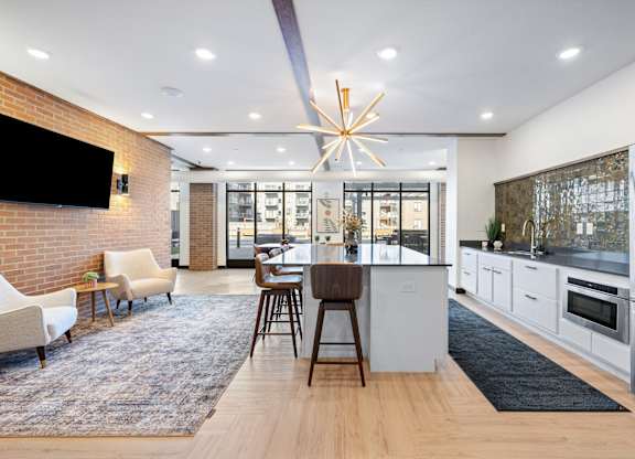 A modern kitchen with a dining area and a television on the wall.