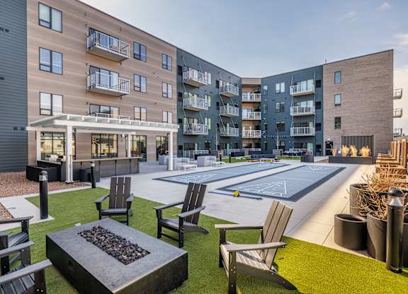 A modern apartment complex with a fire pit in the courtyard.