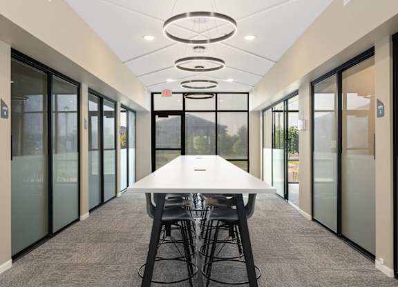 A conference room with a long table and chairs.