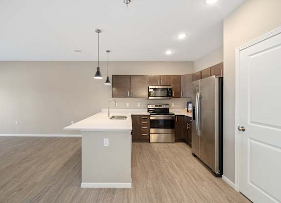 A modern kitchen with a white island and stainless steel appliances.