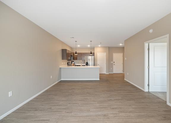 A spacious room with a kitchen island in the middle.