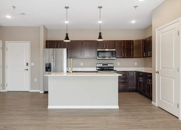 A kitchen with a white island in the middle of it.