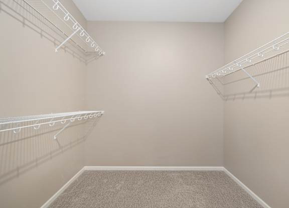 Empty room with white shelves and carpeted floor.