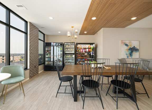 A room with a table and chairs and a fridge.