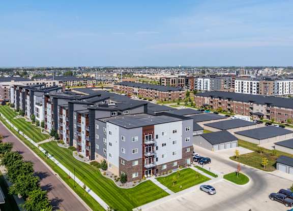 A large apartment complex with a parking lot in front.