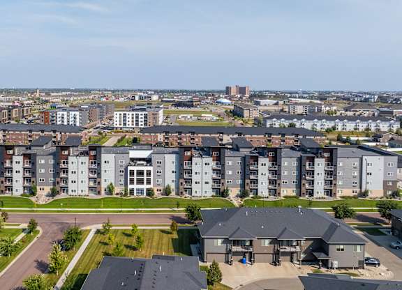 A large apartment complex with a parking lot in front.