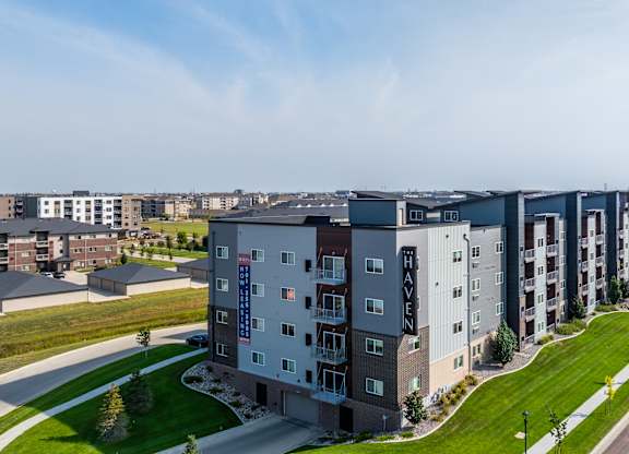 A long row of apartment buildings with a road in front.